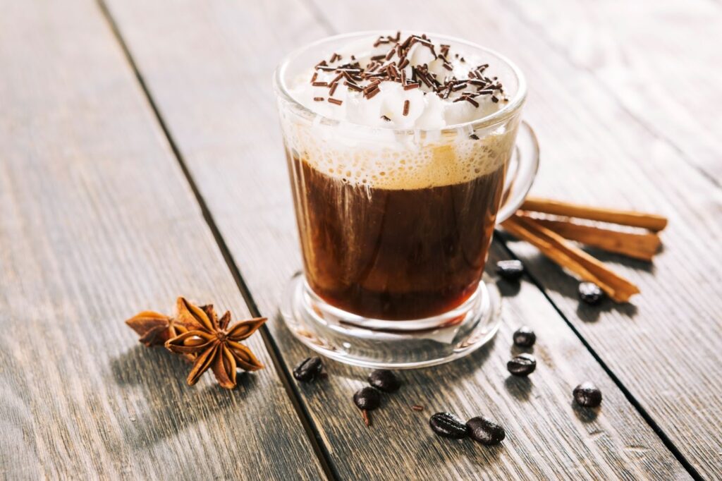 Близък план на чаша ирландско кафе с кафе на зърна и канела за декорация